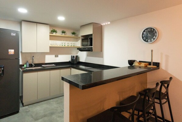Fridge, microwave, coffee/tea maker, cookware/dishes/utensils
