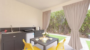 A modern kitchen with a dining table, chairs, and a view of the garden.