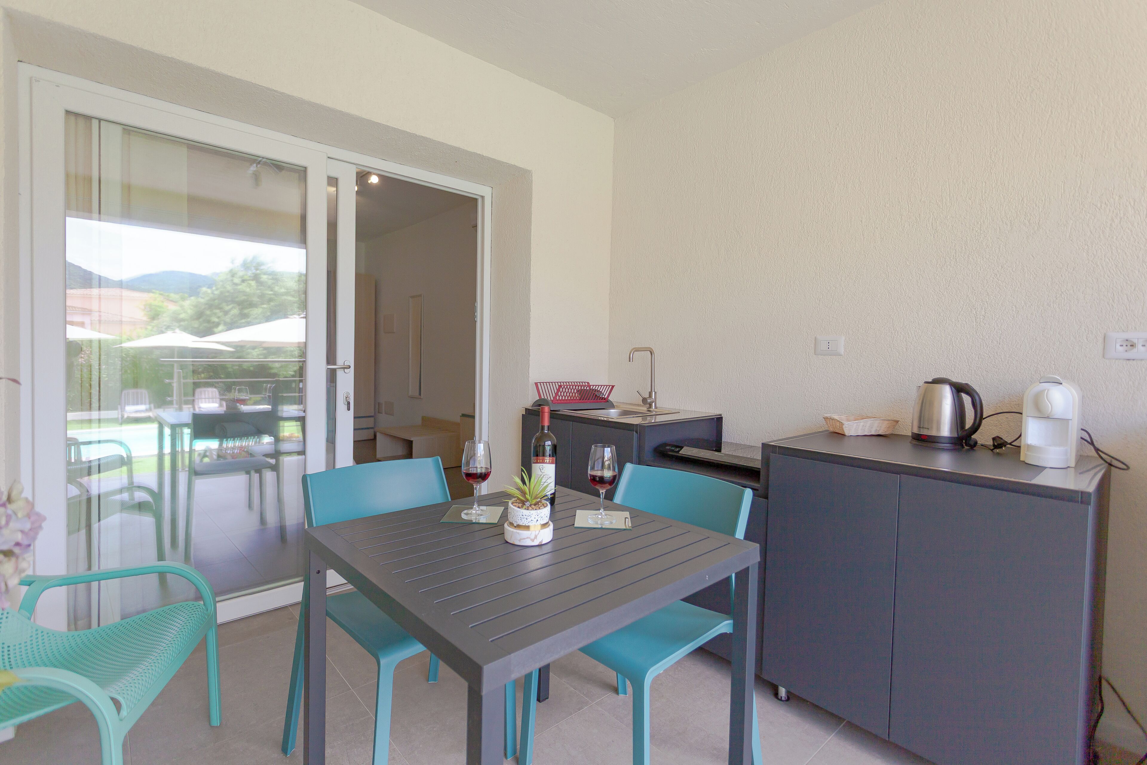 A compact kitchen with a dining table, chairs, and a small cabinet.