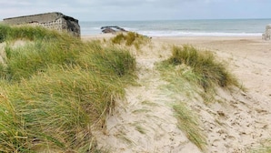 A beach with sand dunes and a stone structure. - 4 Star Holiday Home in Thyboron (Thyborøn)