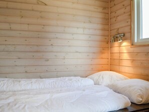 A single bed with white bedding in a room with wooden walls and a window. - 4 Star Holiday Home in Thyboron (Thyborøn)