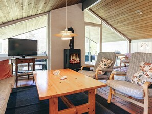 Una sala de estar acogedora con una mesa de madera, un sofá, un televisor y una chimenea.