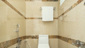 Un bagno piccolo e moderno, con il water, una doccia e uno scaldabagno.