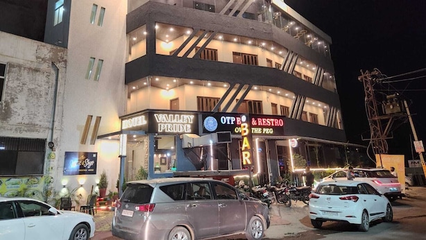 A multi-story hotel with a prominent sign for 'Valley Pride' and 'OTP Bar & Restro'.