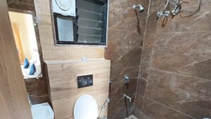 A bathroom with a toilet, sink, and shower.