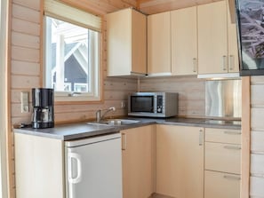 A compact kitchen with a built-in microwave, a coffee maker, and a sink. - 4 Star Holiday Home in Thyboron (Thyborøn)