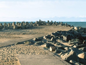A beach with large concrete structures and a sandy path. - 4 Star Holiday Home in Thyboron (Thyborøn)