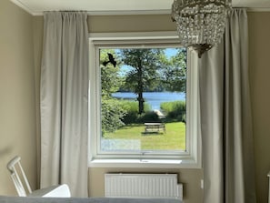 A room with a large window, a radiator below, and a white chair. - 4 Star Holiday Home in Sollentuna (Sollentuna)