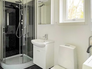 A bathroom with a glass-enclosed shower, a white sink, and a toilet. - 4 Star Holiday Home in Sollentuna (Sollentuna)