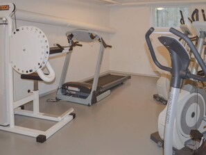 A gym with various exercise equipment including a treadmill, elliptical, and weight machine. - 5 Star Holiday Home in Thyboron (Thyborøn)