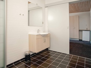 A bathroom with a sink, mirror, and cabinets.