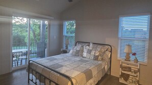 A bedroom with a bed, a ceiling fan, a nightstand with a lamp, and a window with blinds. - Charming 1-bedroom farmhouse in marvelous Seneca with WiFi, AC (Seneca)