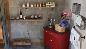 A rustic room with a wooden cabinet, shelves with jars, a wicker basket with flowers, and a red dresser. - Charming 1-bedroom farmhouse in marvelous Seneca with WiFi, AC (Seneca)