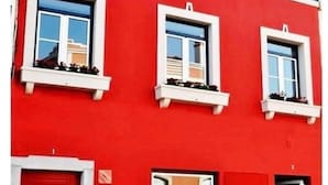 A red building with three windows on the upper floor and a red door on the lower floor. - Lagos Marina Studio- King Bed- Ensuite- Balcony (Lagos)