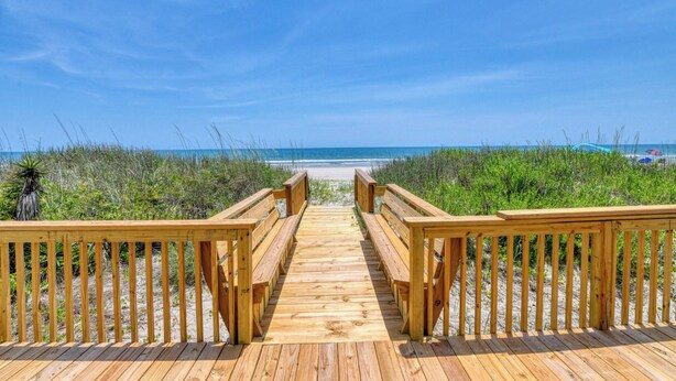 A wooden boardwalk leading to a beach with a clear blue sky. - Peace of Heaven Three Bedroom Oceanfront Home in Long Bay Estates (Myrtle Beach)