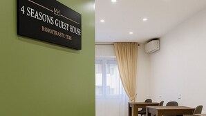 Een vergaderzaal met een bord waarop staat: 4 SEASONS GUEST HOUSE ROMATRASTE TERE.