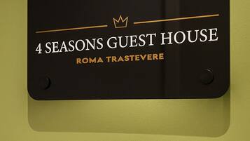 A sign for "Autumn 4 Seasons Guest House" with a keypad below it.