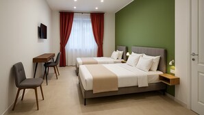 Een hotelkamer met twee bedden, een bureau en een stoel.