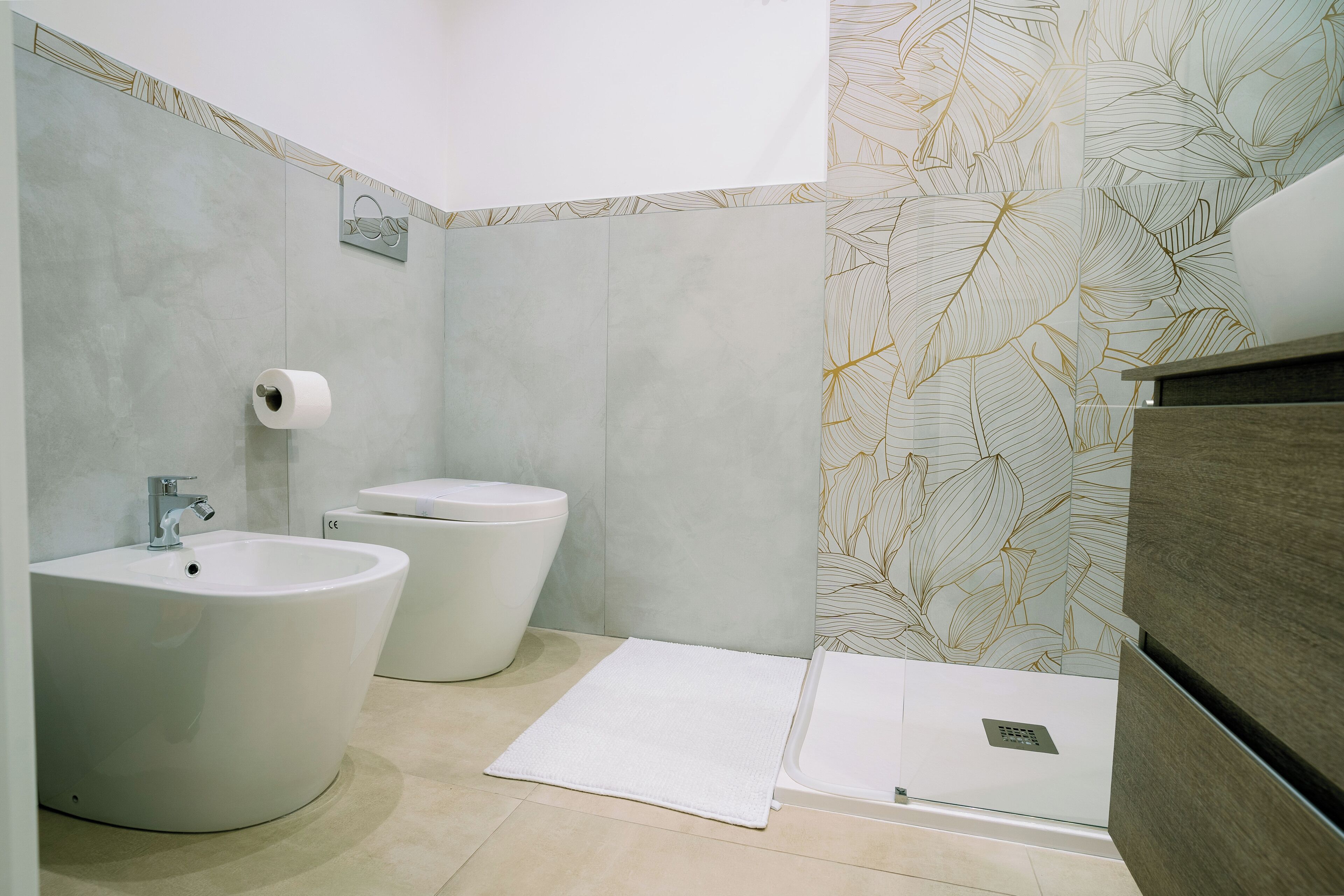 Ein modernes Badezimmer mit Bidet, Toilette und Waschbecken.