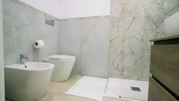 Ein modernes Badezimmer mit Bidet, Toilette und Waschbecken.