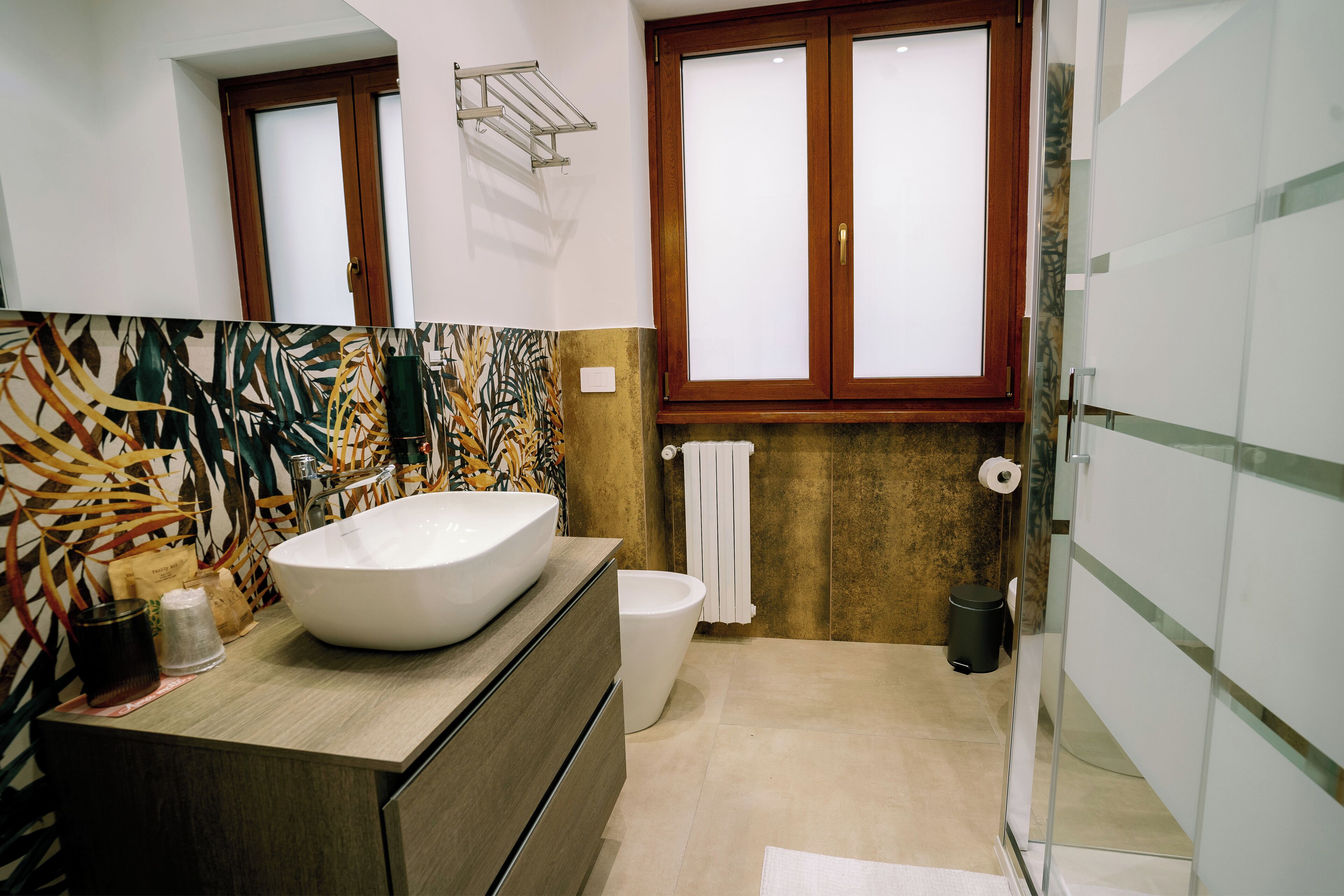 Een moderne badkamer met een grote wastafel, een toilet en een douchecabine met glazen wanden.
