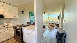 A modern kitchen with white cabinets, a built-in oven, and a large island.