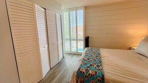A bedroom with a bed, a window, and a door.