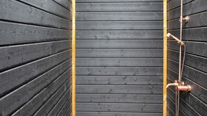 A wooden cabin with a metal shower enclosure. - 5 Star Holiday Home in Sjaellands Odde (Sjællands Odde)