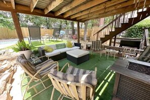 An outdoor patio with a wooden pergola, a sofa set, a grill, and a pool in the background. - Epic Stay Pool + Fire Pit + *Location* (Fort Worth)