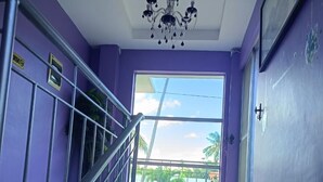 Una escalera con barandillas de metal que lleva a un balcón con puerta de cristal.