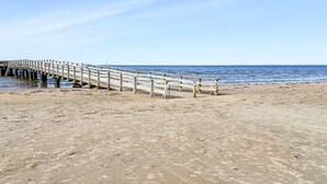 A wooden pier extending into the sea with a sandy beach in the foreground. - 4 Star Holiday Home in Laholm (Skummesloevsstrand)