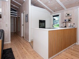 Et moderne køkken med en træø, indbygget ovn og et vindue med udsigt til en have.