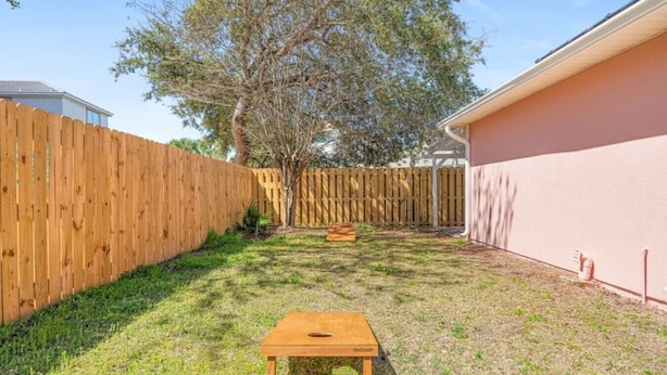 Ein Garten mit Holzpfeilung, einem kleinen Holztisch und einem Baum.