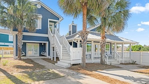 A two-story house with a covered porch, a staircase, and a fenced yard. - 5BDR Renovated Home~Private Pool + Games (Destin)