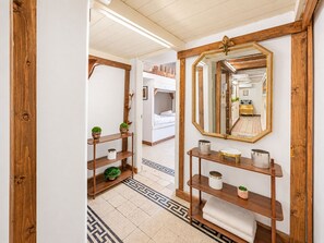 A hallway with wooden shelving, a mirror, and a patterned floor. - 4BNB - Victoria Palace (Rome)
