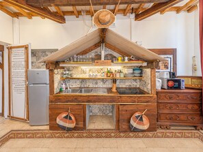A rustic kitchen with wooden beams, a refrigerator, a microwave, and a wooden cabinet with drawers. - 4BNB - Victoria Palace (Rome)