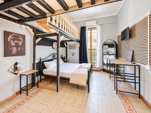 A bedroom with a bunk bed, a desk, a mirror, and a window with curtains. - 4BNB - Victoria Palace (Rome)
