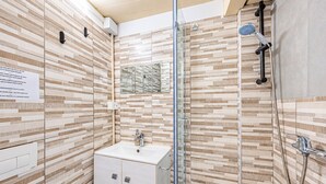 A bathroom with a shower, a sink, and a cabinet.