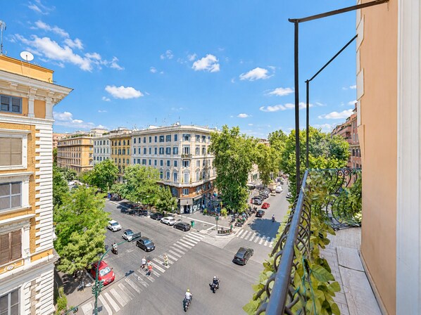 A street view with buildings, a crosswalk, and vehicles.