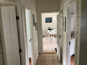 A hallway leading to a dining area with a tiled floor and white furniture. - 5 Person Holiday Home in Nakskov (Nakskov)