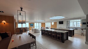 Una cocina moderna con una isla central, un comedor con mesa de madera y un amplio ventanal que proporciona luz natural.