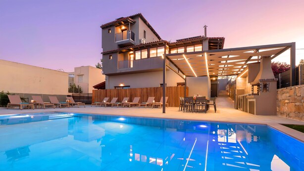 Une maison moderne à deux étages dotée d’une piscine, d’un espace salon extérieur et d’un patio couvert.