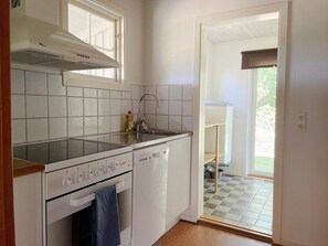 A compact kitchen with a dishwasher, oven, and a window above the sink. - 4 Person Holiday Home in Klintehamn (Klintehamn)