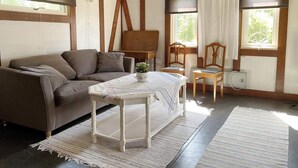 A cozy room with a sofa, a small table with a plant, and two chairs. - 4 Person Holiday Home in Klintehamn (Klintehamn)