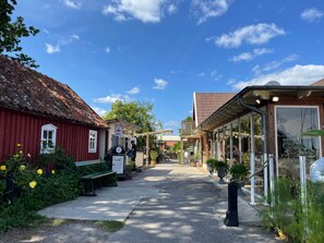 A narrow street with buildings on either side, including a red building with a white window and a sign that says "STOP OPPETT". - Semi-detached House 210m From Beach (Fågelmara)