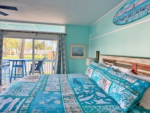 Una camera da letto con un letto, una finestra, vista sull'esterno e una ventola a soffitto.