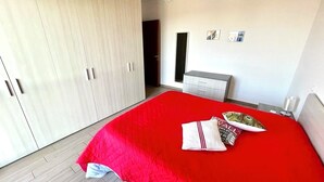 Une chambre à coucher avec un grand lit, une armoire et une table de chevet.