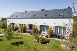 A modern building with a flat roof, large windows, and outdoor seating area.