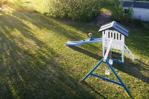 A playground with a slide and a climbing structure.