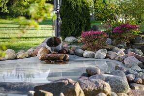 A garden with a pond, rocks, and flowering plants.